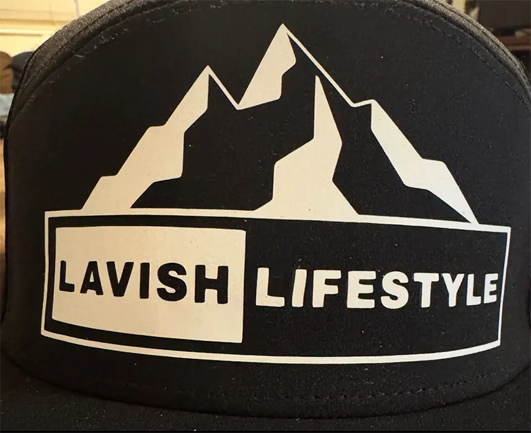 Black cap with a mountain graphic and the text "Lavish Lifestyle" in bold white font.